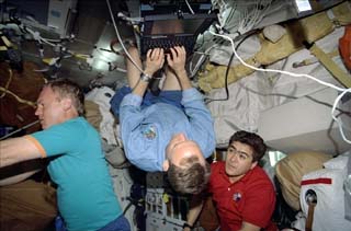 STS-89 Pilot Joe Edwards checking his e-mail on a Spacehab Payload and General Support Computer (PGSC) onboard the Orbiter Endeavour, Mission Specialist Andrew Thomas and Mission Specialist Salizhan Sharipov.